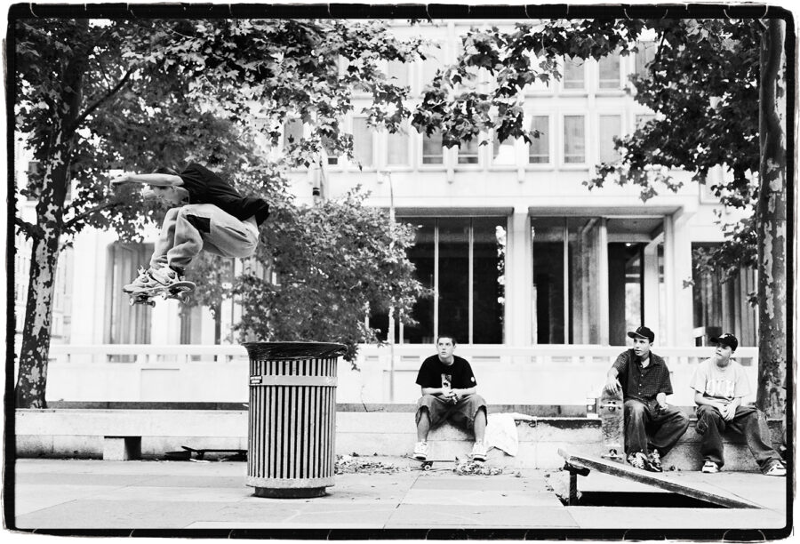 Josh Kalis – 360 flip out off a propped up paving slab and over a trash can at Love Park shot by Mike Blabac.