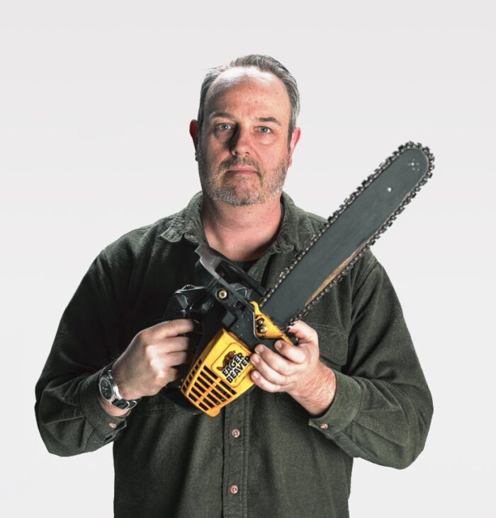 Mark Lewman holding a chainsaw.