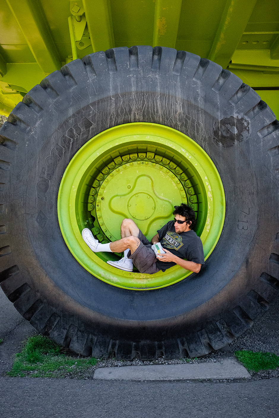 Erick Winkowski reclining in the wheel of the largest truck in the Northern Hemisphere with a Subway sandwich. Photo shot by Kyle Seidler and selected for his Slam City Skates 5000 Words interview